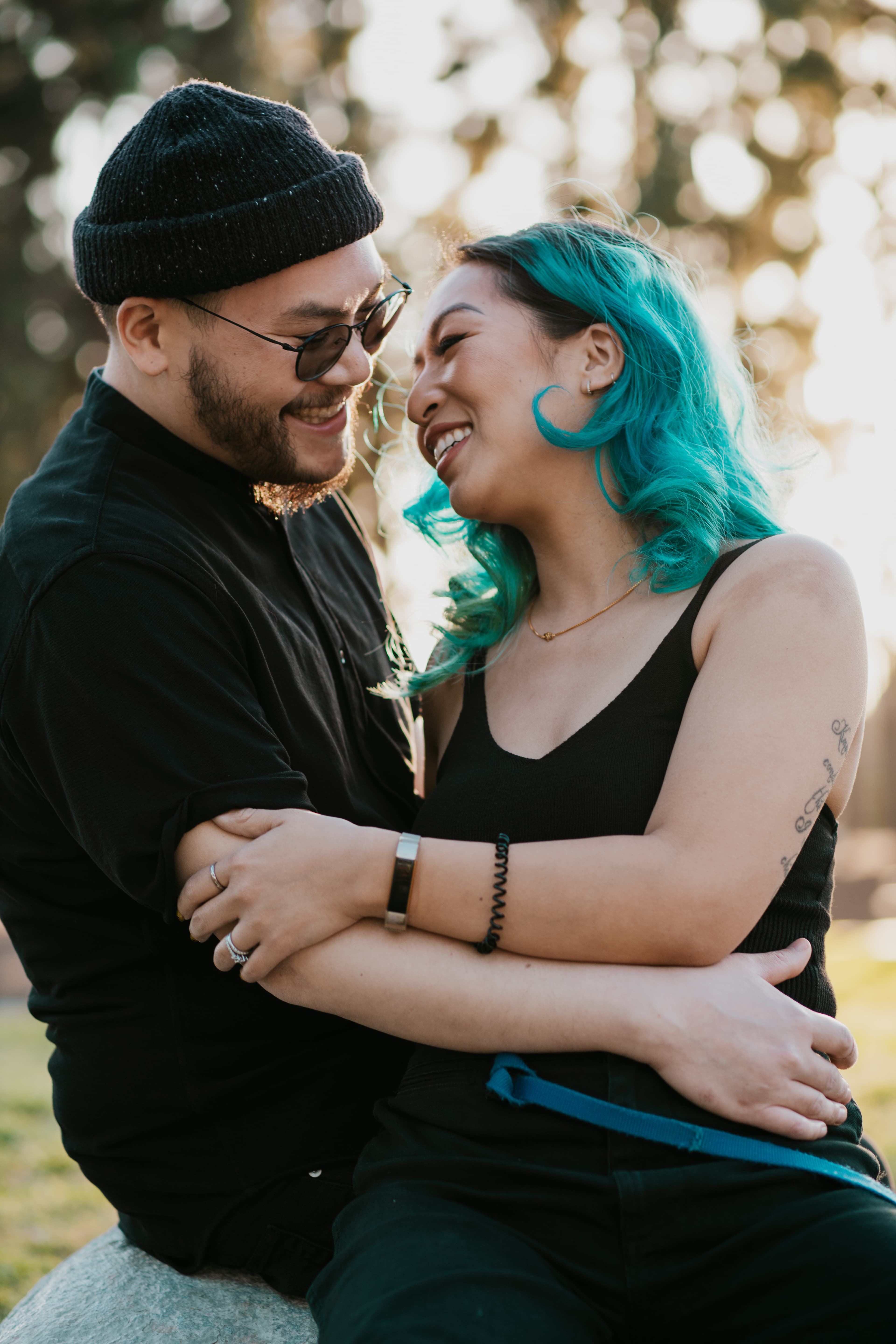 A laughing couple embracing outdoors.