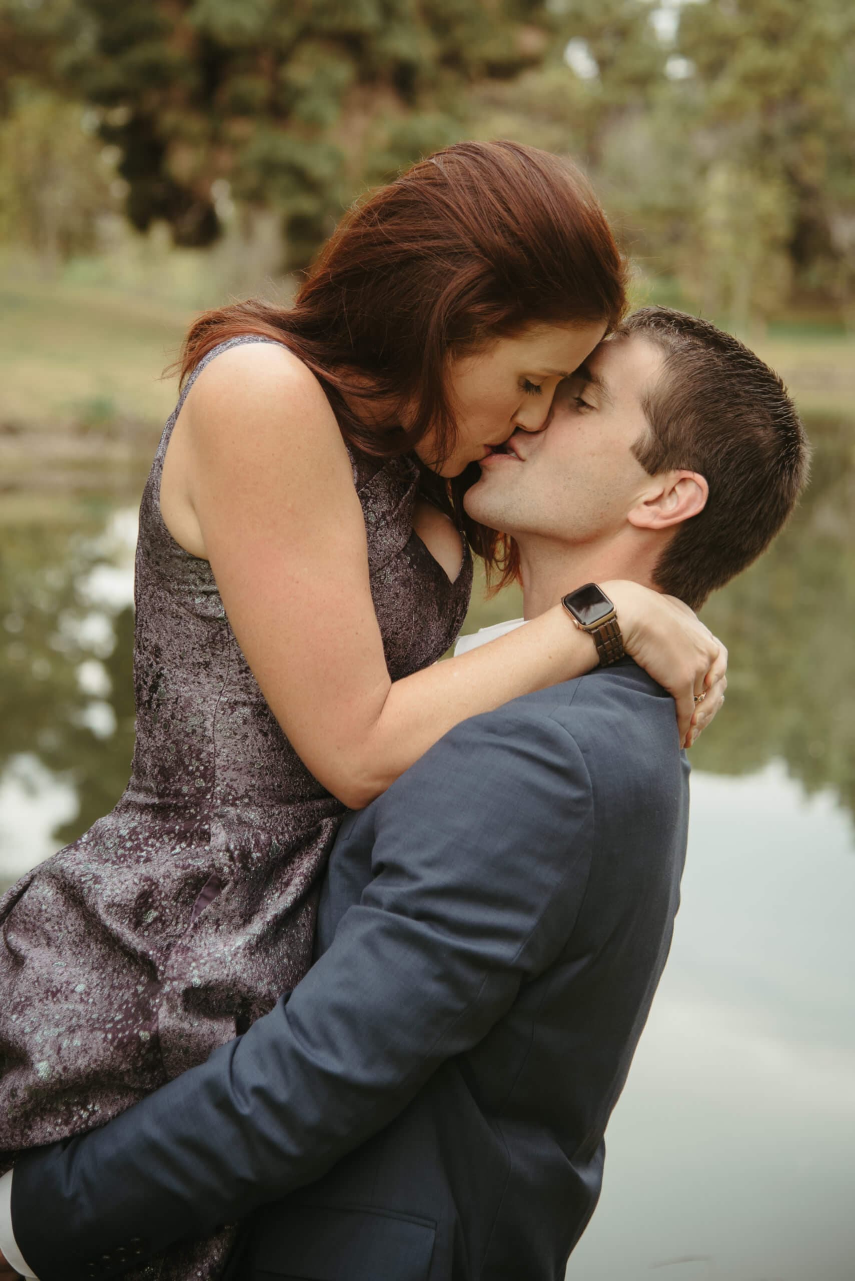 A couple kissing, with the woman wrapping her arms around the man's neck