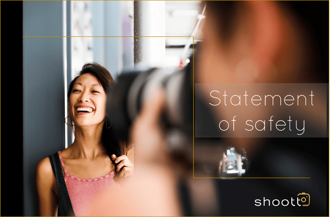 A woman smiling at a photographer who is taking her picture.